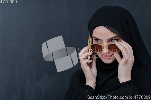 Image of Young muslim businesswoman in traditional clothes or abaya using smartphone