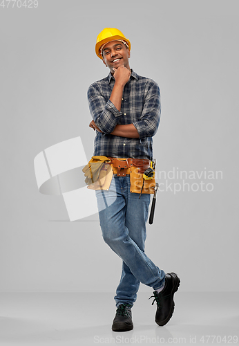 Image of happy indian builder in helmet with tool belt