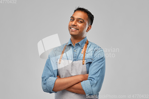 Image of smiling indian barman, waiter or salesman in apron