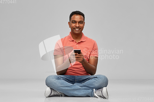 Image of happy indian man using smartphone