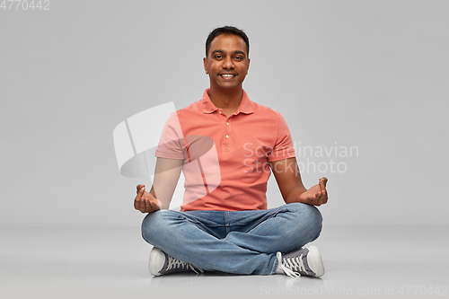 Image of happy indian mant meditating in lotus yoga pose