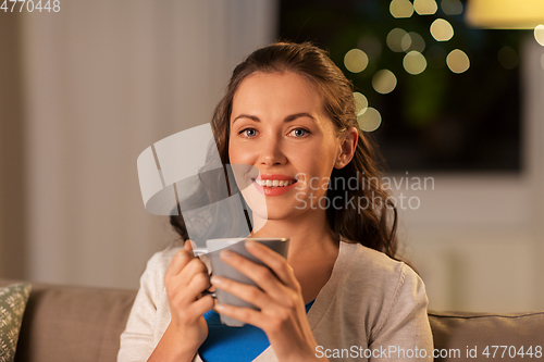 Image of happy woman drinking tea or coffee at home