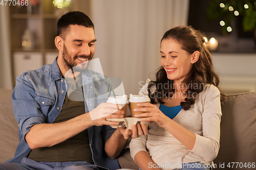 Image of happy couple drinking tea or coffee at home