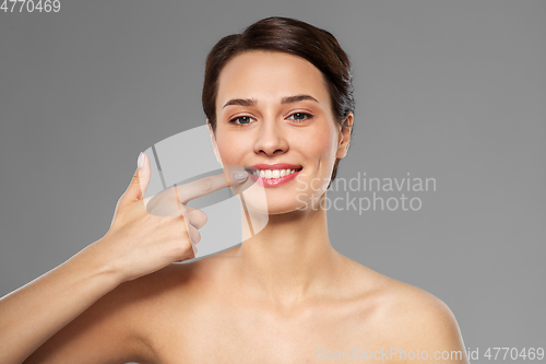 Image of smiling young woman pointing to her mouth