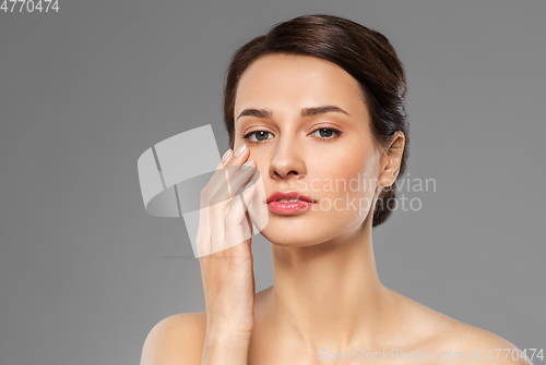 Image of beautiful young woman touching her face