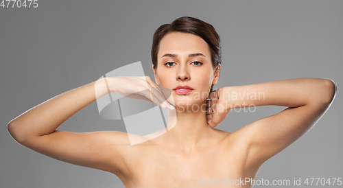 Image of beautiful young woman touching her face