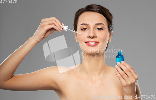 Image of woman with dropper applying serum to her face