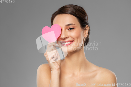 Image of beautiful woman closing one eye with pink heart