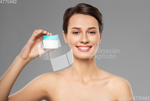Image of happy young woman holding jar of cream