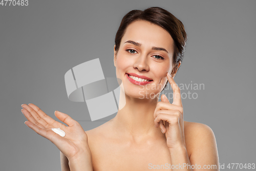 Image of young woman with moisturizing cream on finger