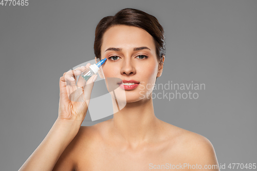 Image of beautiful young woman with eye drops
