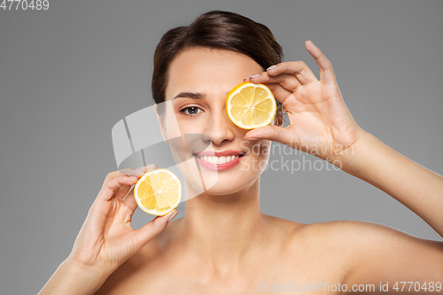 Image of beautiful woman making eye mask of lemon slices