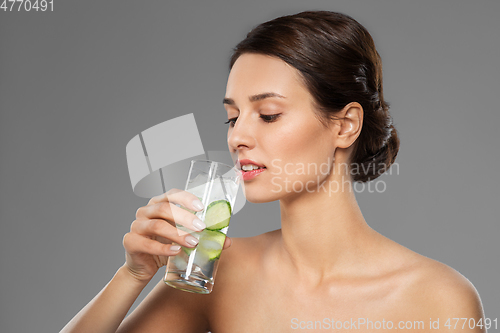 Image of woman drinking water with cucumber and ice