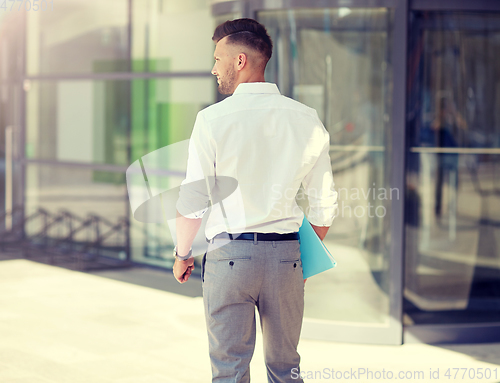 Image of young man with folder on city street