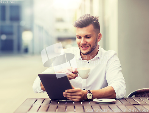 Image of man with tablet pc and coffee at city cafe