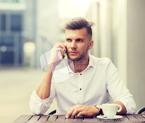 Image of man with coffee calling on smartphone at city cafe