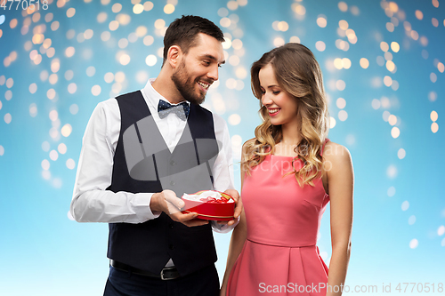 Image of happy couple with chocolate box in shape of heart