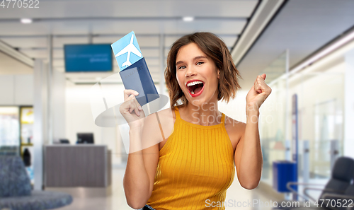 Image of happy young woman with air ticket and passport