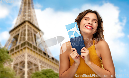 Image of happy woman with air ticket over eiffel tower