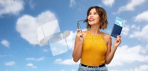 Image of happy young woman with air ticket and passport