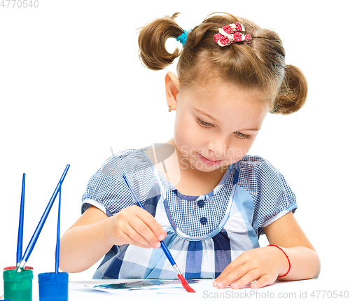 Image of Little girl is painting with gouache