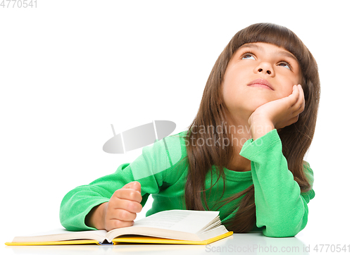 Image of Young girl is daydreaming while reading book