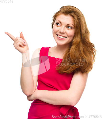 Image of Portrait of a young woman pointing to the left