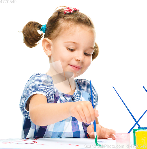 Image of Little girl is painting with gouache