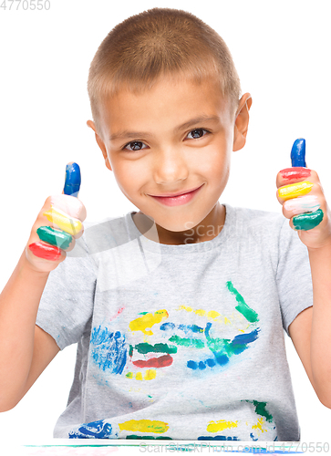 Image of Portrait of a cute boy playing with paints