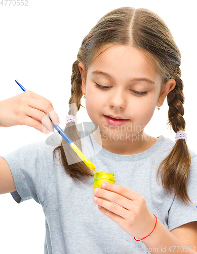 Image of Little girl is painting with gouache