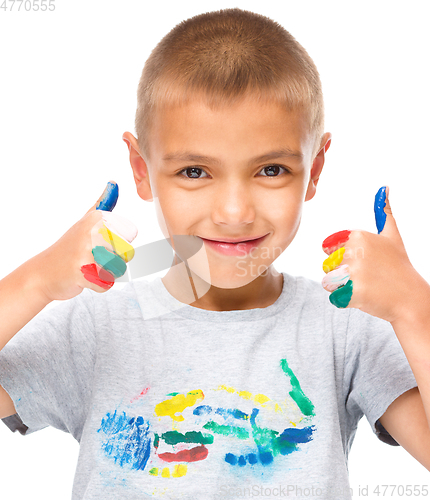 Image of Portrait of a cute boy playing with paints