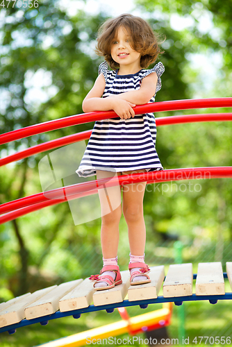 Image of Cute little girl is playing in playground