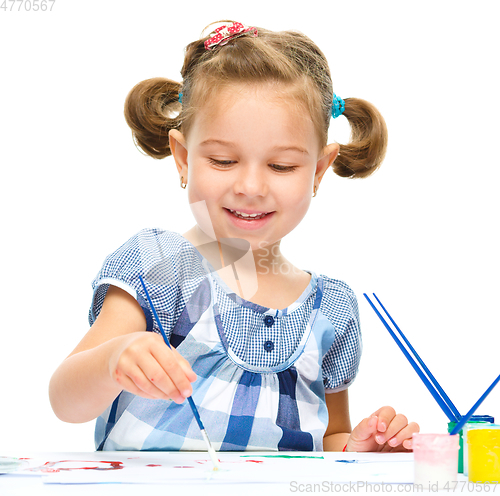 Image of Little girl is painting with gouache