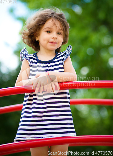 Image of Cute little girl is playing in playground