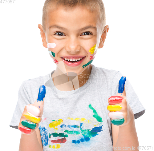 Image of Portrait of a cute boy playing with paints