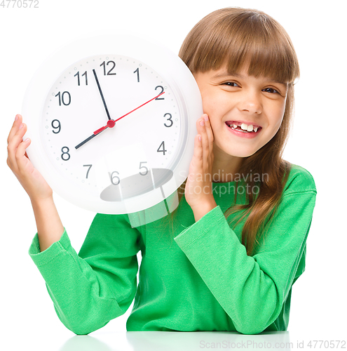 Image of Little girl is holding big clock