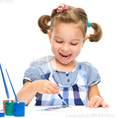 Image of Little girl is painting with gouache