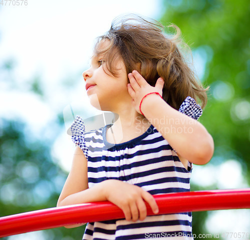 Image of Cute little girl is playing in playground