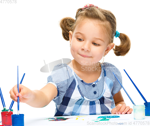 Image of Little girl is painting with gouache