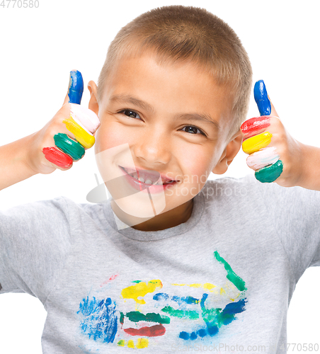 Image of Portrait of a cute boy playing with paints