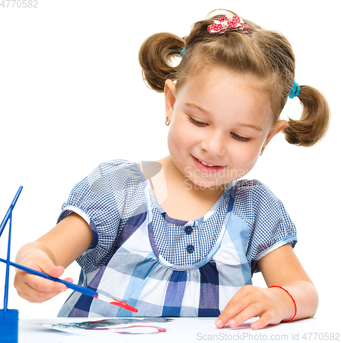 Image of Little girl is painting with gouache