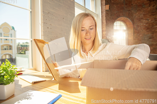 Image of A young businesswoman moving in office, getting new work place