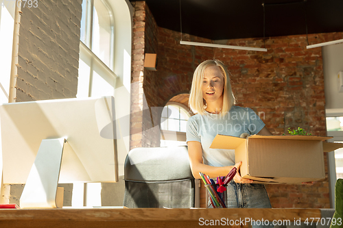 Image of A young businesswoman moving in office, getting new work place
