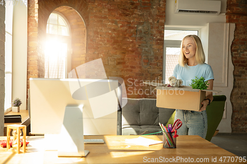 Image of A young businesswoman moving in office, getting new work place