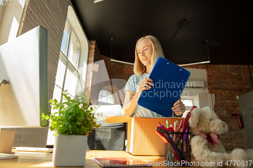 Image of A young businesswoman moving in office, getting new work place