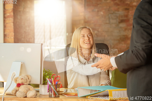 Image of A young businesswoman moving in office, getting new work place