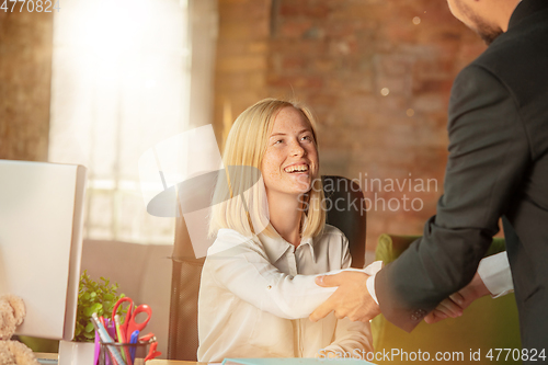 Image of A young businesswoman moving in office, getting new work place