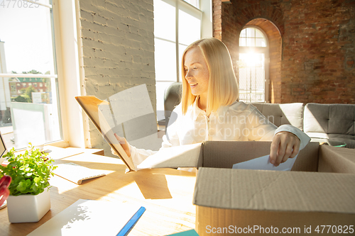 Image of A young businesswoman moving in office, getting new work place