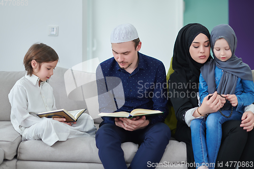 Image of Young muslim family reading Quran during Ramadan