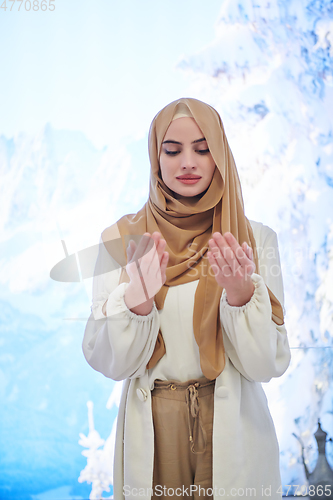 Image of Portrait of young muslim woman praying or making dua to God